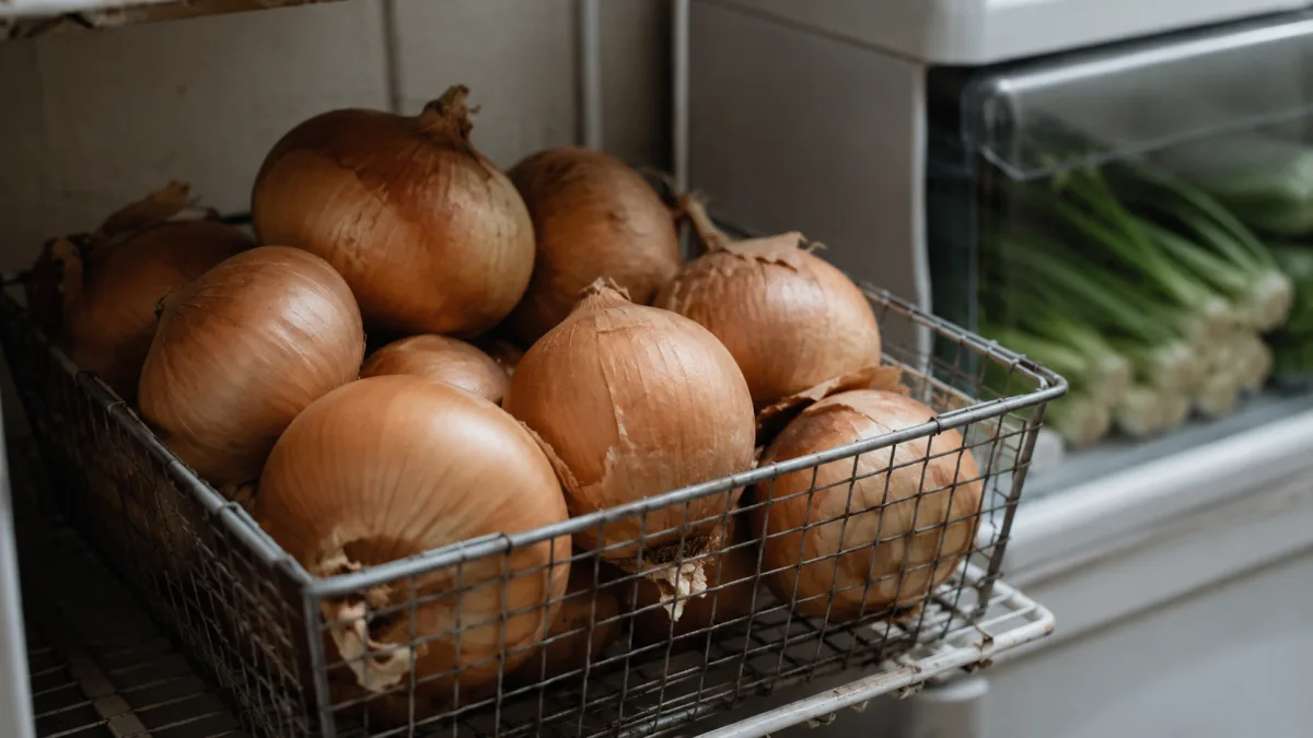 Onions stored in a ventilated basket in a dark pantry