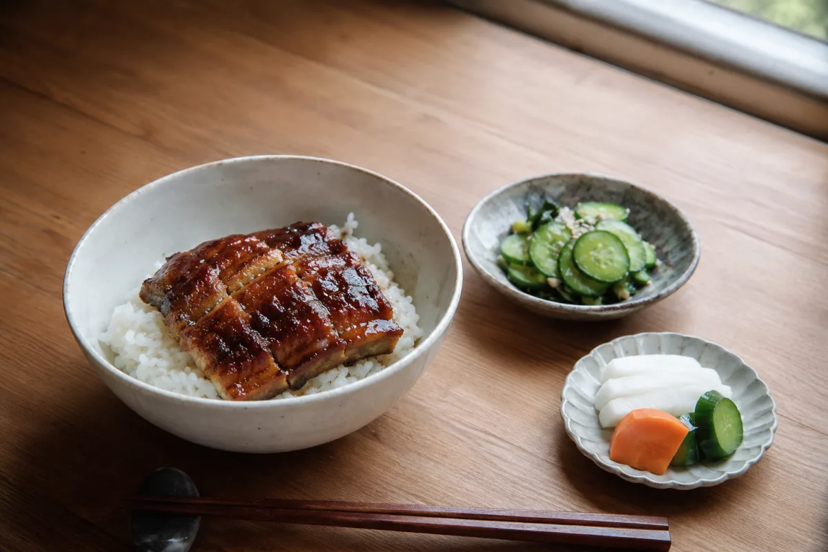 Glazed eel served with rice, cucumber, and pickled vegetables