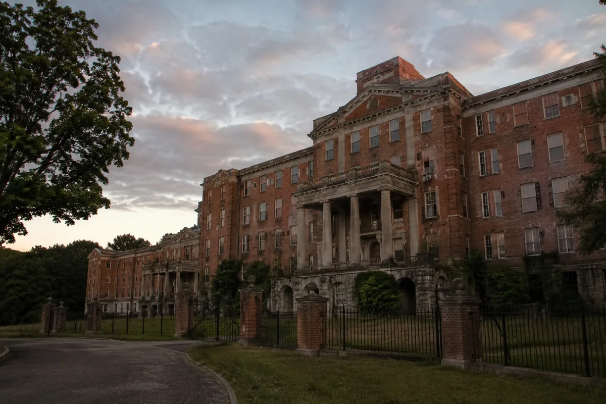 Exterior of an old brick sanatorium-style building at dusk