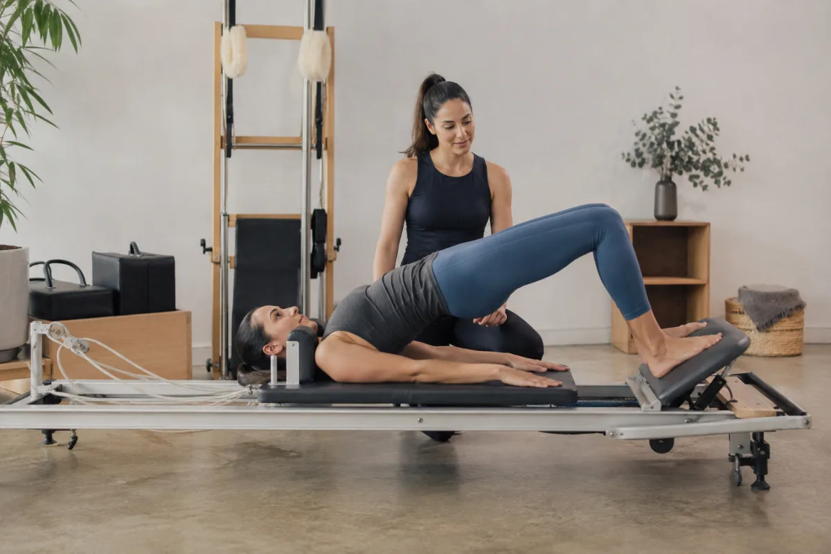 Pilates student practicing controlled jump board form on reformer