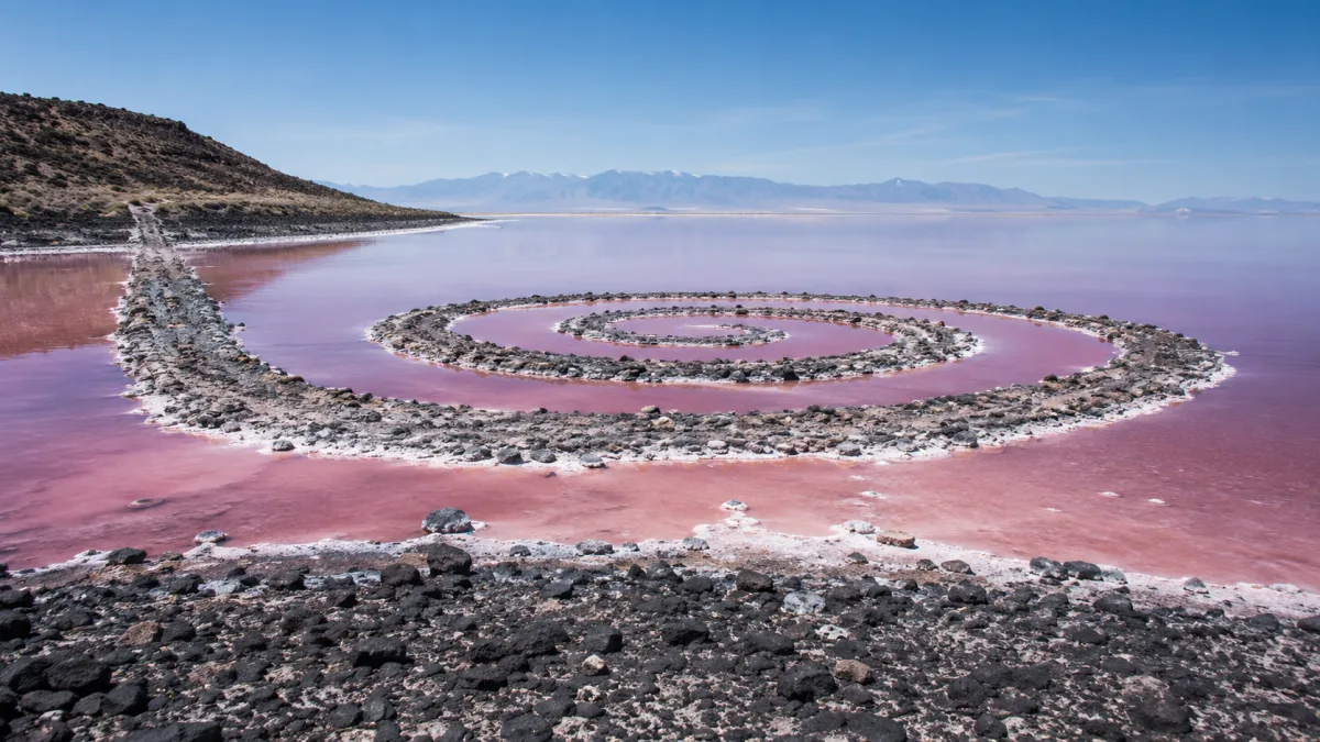 The Spiral Jetty's black basalt coil curling into the pink waters of the Great Salt Lake at Rozel Point, Utah