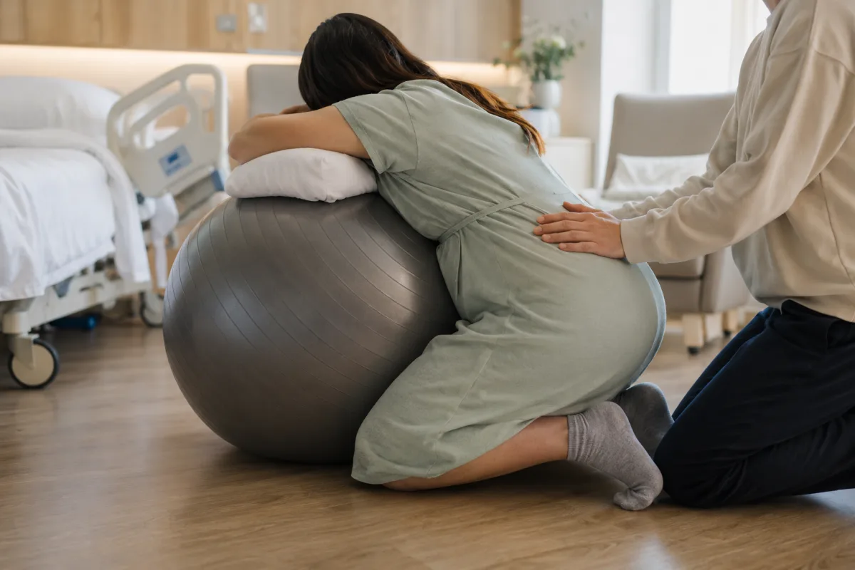 Kneeling lean over birthing ball