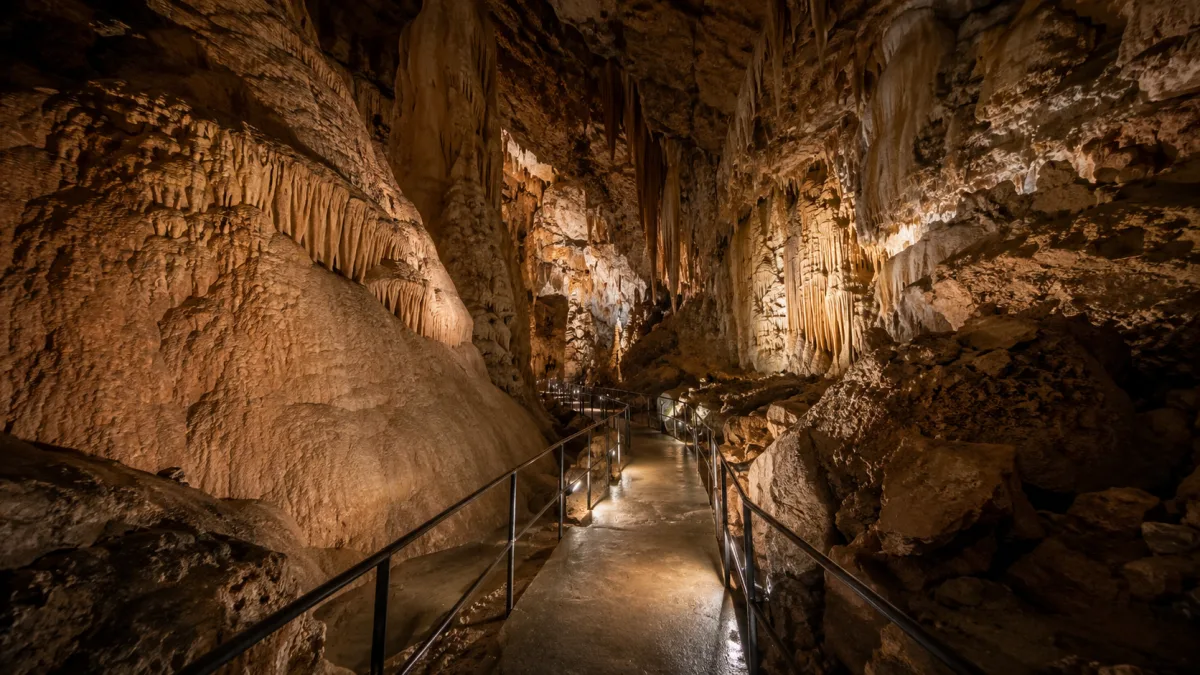 Cave walkway with formations and low light